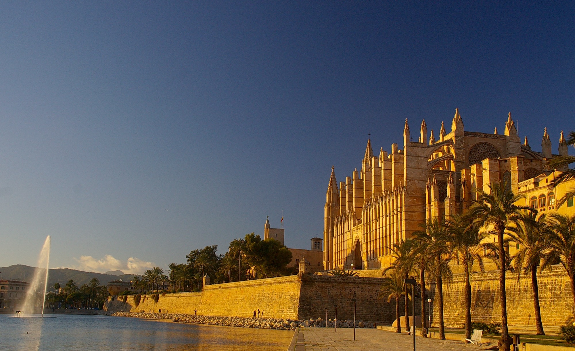 La catedral de Palma iluminada por el sol de la tarde, junto al Parc de la Mar